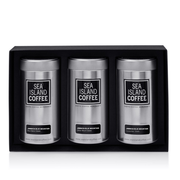 Three Sea Island Coffee tins in a black box on a white background